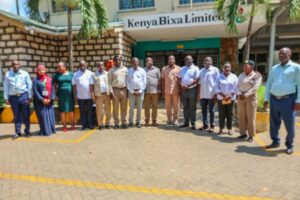 Group of people standing in a line outside a Kenya Bixa Limited building for a group photo.