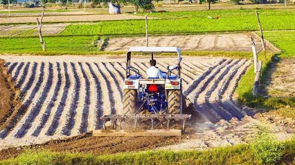 images - 2026-09-25T135516474 - Sacco Trend Magazine Tractor plowing a field, creating evenly spaced furrows with soil turned up, green fields in the background.