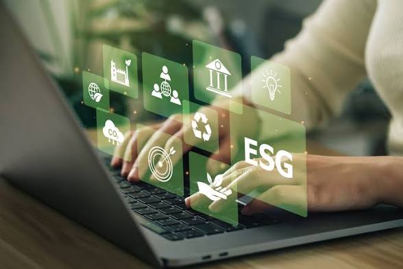 images - 2026-10-13T111656289 - Sacco Trend Magazine Businessperson typing on a laptop with floating ESG icons (environment, social, governance) above the keyboard.